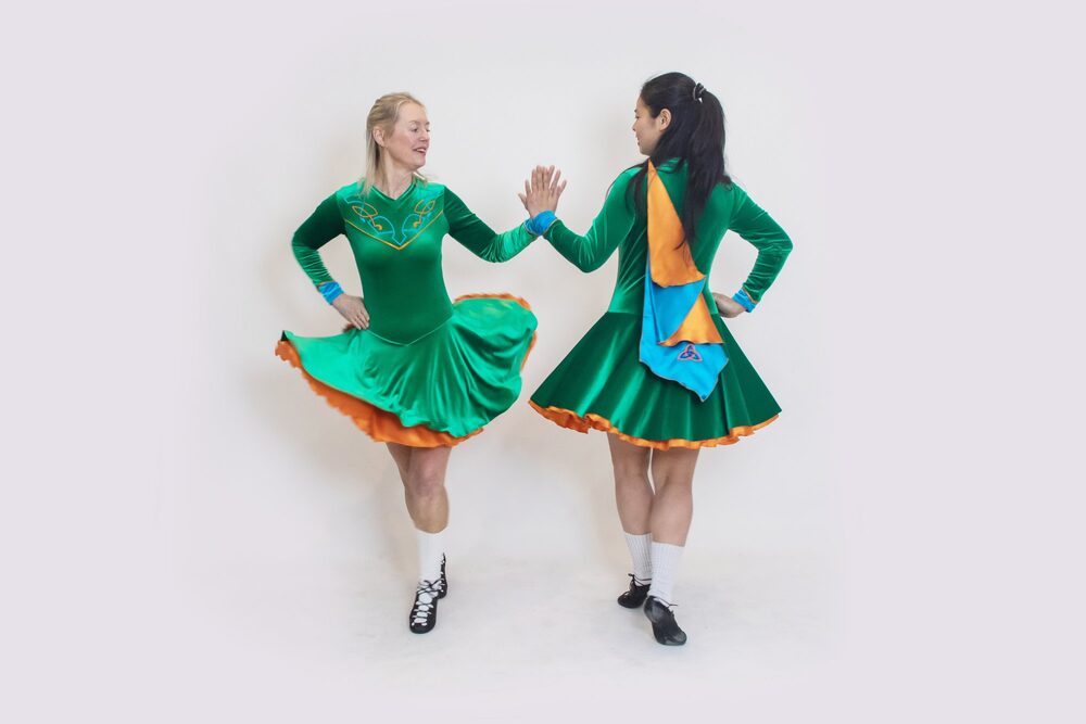 Michelle Irish dancing in a green dress with a fellow dancer